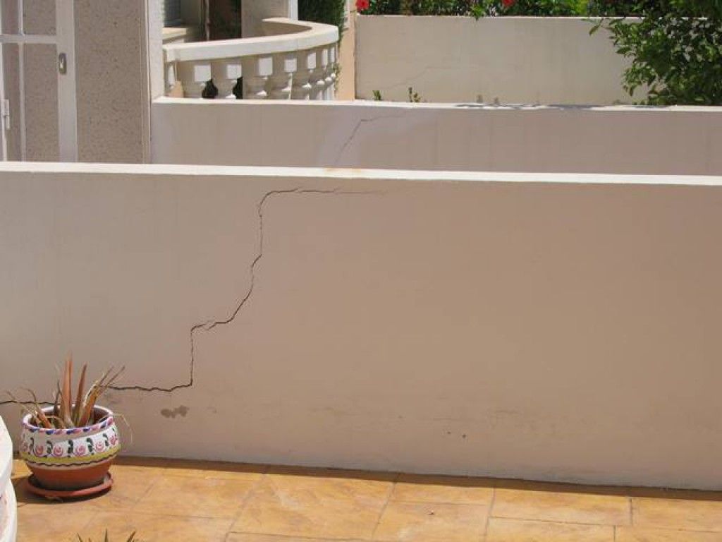 muro divisorio con grieta en forma de escalera